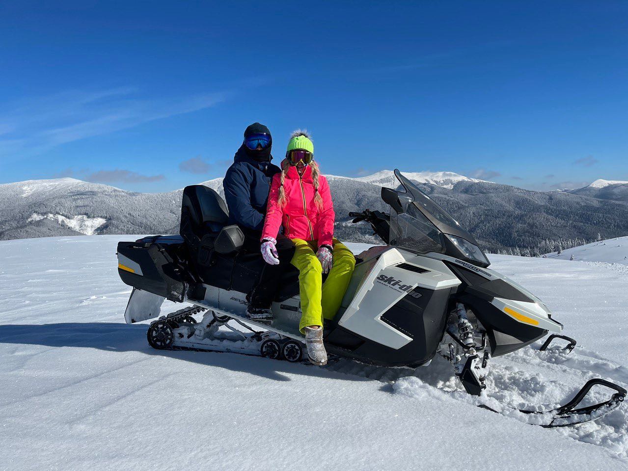 Двоє гостей на снігоході Ski-Doo на тлі зимових Карпат